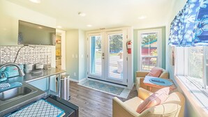 A kitchen with a sink, stove, and a window overlooking a garden. - Dogs Ok, Large Deck, BBQ, Fire pit, Close to Beach (Brock) (Long Beach)