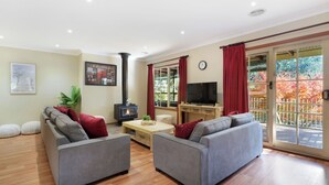 A living room with two grey sofas, a wooden coffee table, a TV, and a fireplace.
