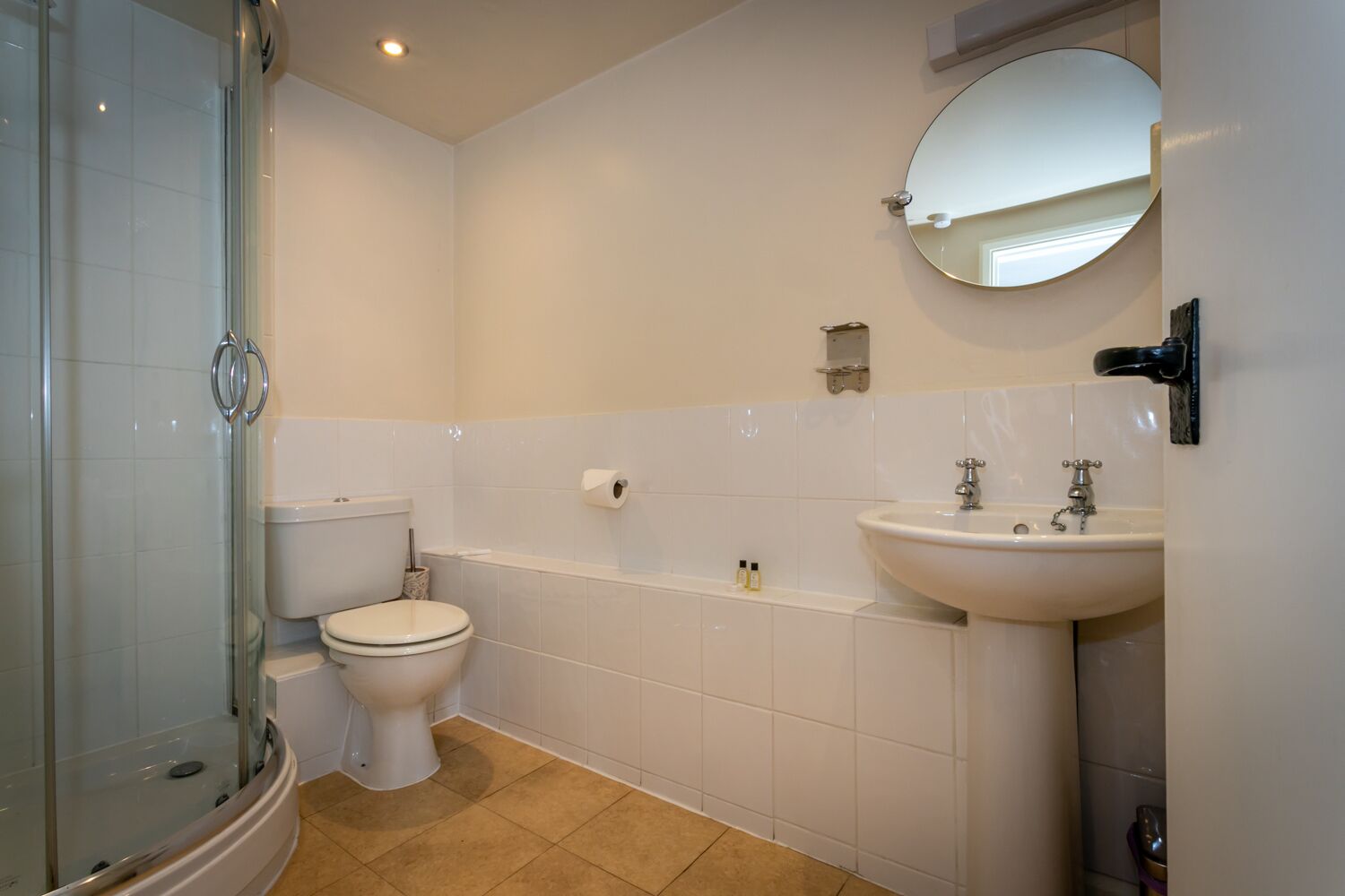 Un baño con cabina de ducha de vidrio, inodoro, bañera y lavabo con espejo.