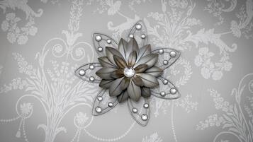 Een decoratieve metalen bloem met een edelsteen in het midden, voor een behang met een patroon.