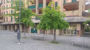 A building with multiple balconies, a paved area with benches, and a sign indicating a security entrance. -  All Inclusive Deluxe Penthouse Studio (Sestri Levante)