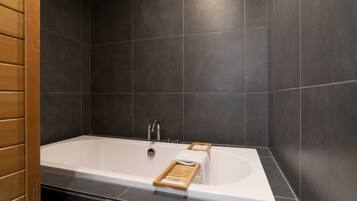Bathtub, hair dryer, towels, shampoo