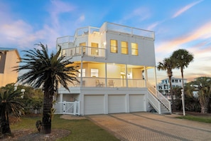 A two-story house with a balcony, a garage, and a staircase leading to the upper level. - Stunning Lakefront Escape Steps to Beach w/ Pool, Spa, & Gulf-View Rooftop Deck (Seagrove Beach)