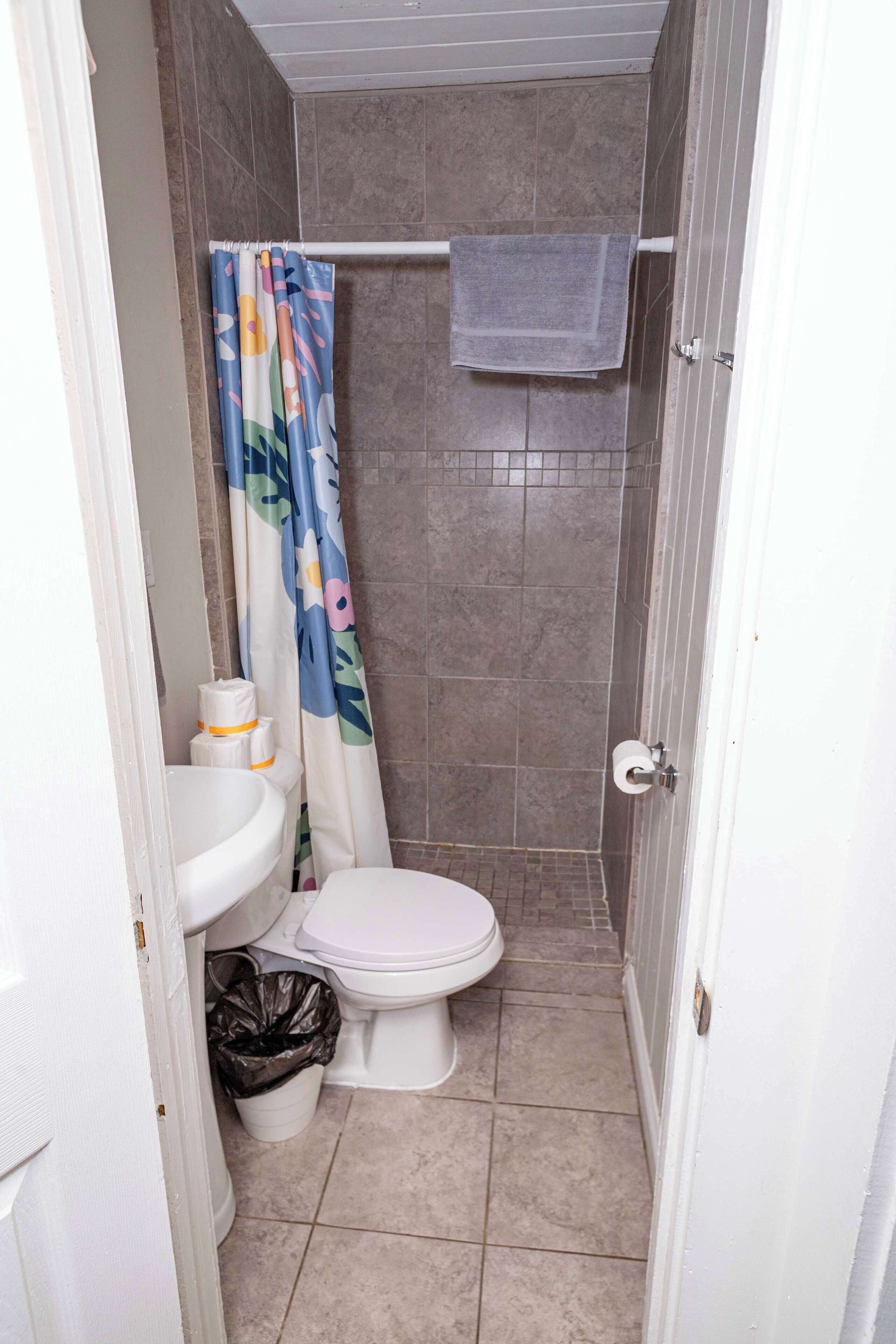 Une petite salle de bain avec des toilettes, un lavabo et un rideau de douche.