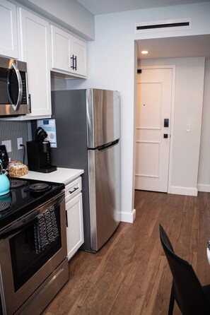 A modern kitchen with stainless steel appliances, a microwave, a kettle, and a coffee maker.