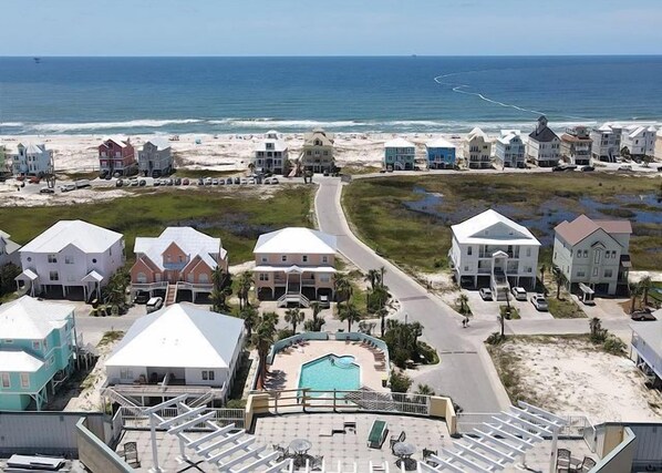 A coastal residential area with houses, a swimming pool, and a beach. - 3BR/3BA Corner Condo | Sleeps 6 | Gulf-View Balcony (Gulf Shores)