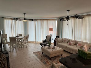 Ein Wohnzimmer mit Essbereich, einer Couch, einem Couchtisch und einer Lampe.