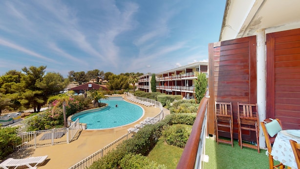 Een hotel met een zwembad, terras en uitzicht op het omliggende landschap.