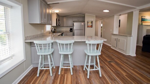 A kitchen with a central island, bar stools, and a refrigerator. - Sandy Oaks, Soundview House in Salter Path, NC! (Salter Path)