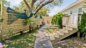 A backyard with a wooden deck, a concrete pathway, and a covered grill area. - Sandy Oaks, Soundview House in Salter Path, NC! (Salter Path)