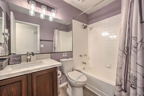 Bagno con lavandino, WC, doccia e uno specchio illuminato.