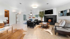 Uma sala de estar moderna com lareira, sofás de couro e um espaço para refeições.