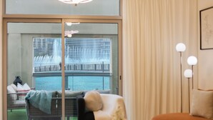 Quarto de hotel com vista para uma fonte e uma varanda.