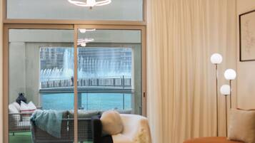 A hotel room with a view of a water fountain and a balcony.