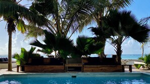 Una piscina al aire libre con palmeras y vista al océano.