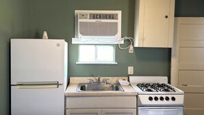A kitchen with a refrigerator, sink, stove, and window. - Budget Inn By Oyo Corpus Christi Beach (Corpus Christi)