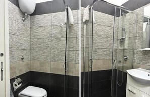 Ein modernes Badezimmer mit einer Duschkabine aus Glas, einem weißen Waschbecken und einer Toilette.