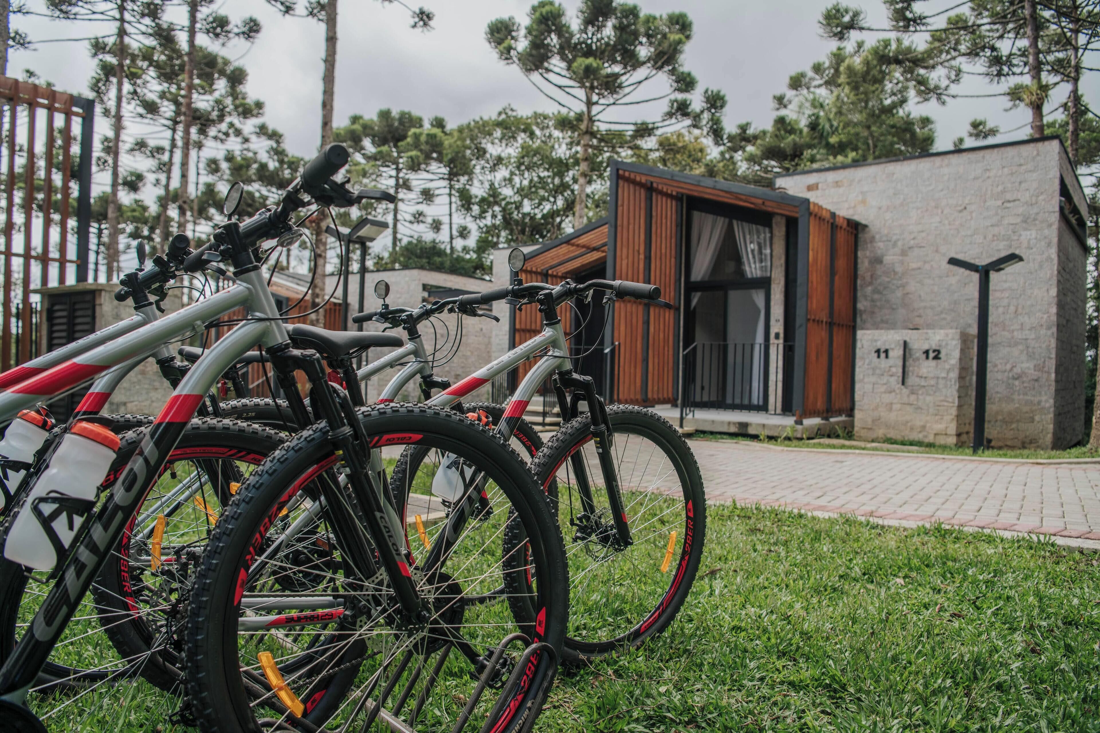 Dos bicicletas estacionadas en un césped, con un edificio al fondo.