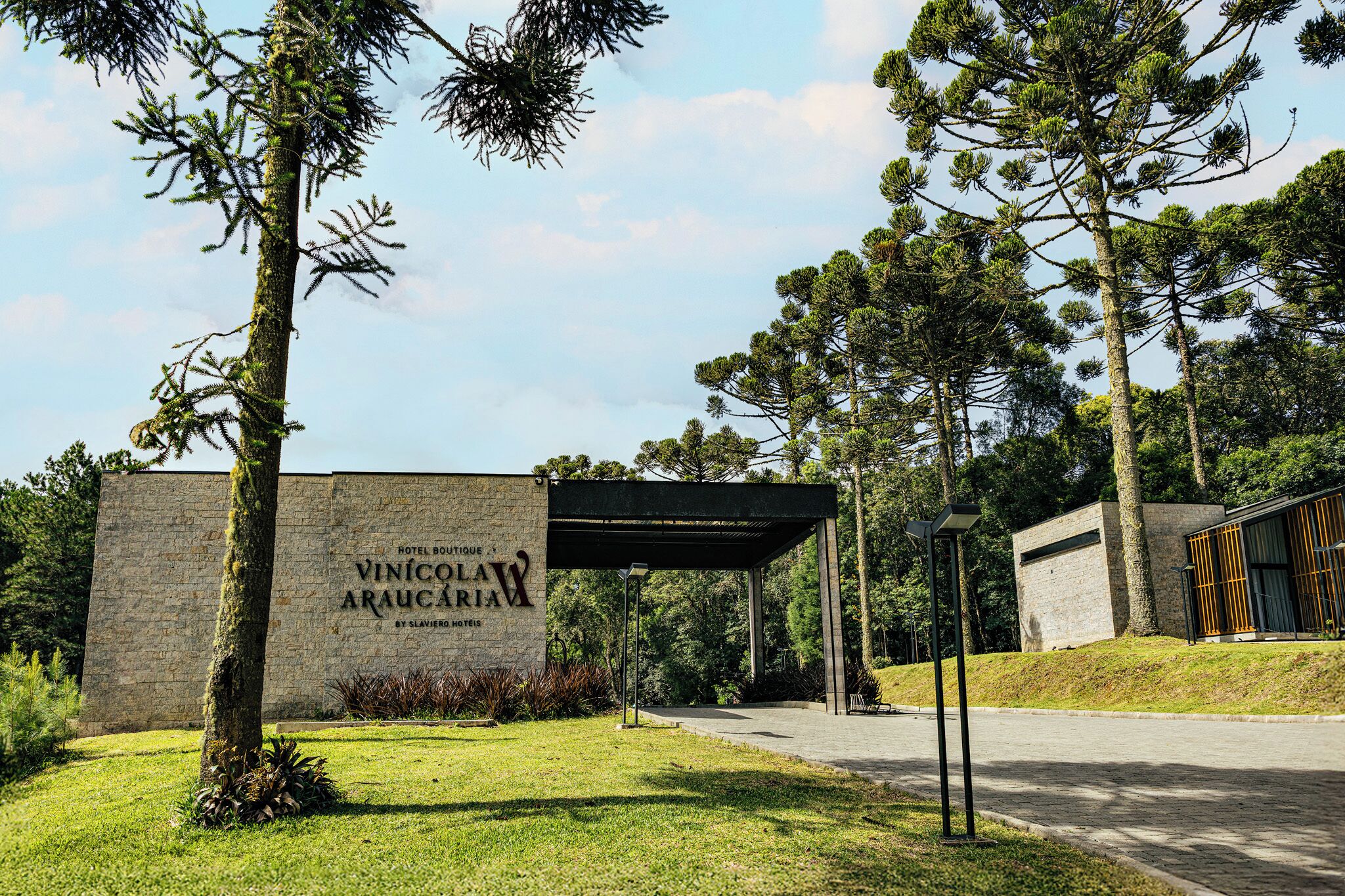A building with a stone facade and a sign that reads "Hotel Boutique Vinicola Araucaria by Slaviere Hotels."