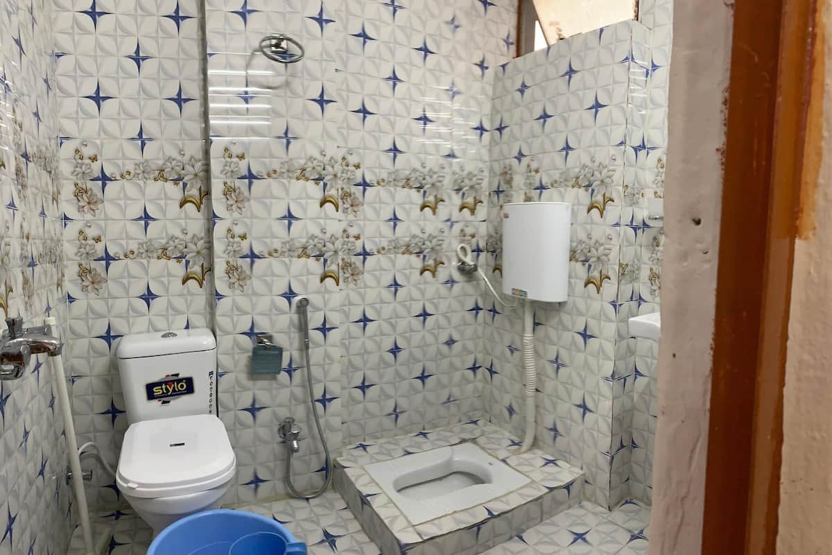 Un baño pequeño con inodoro, bidé y un cubo.