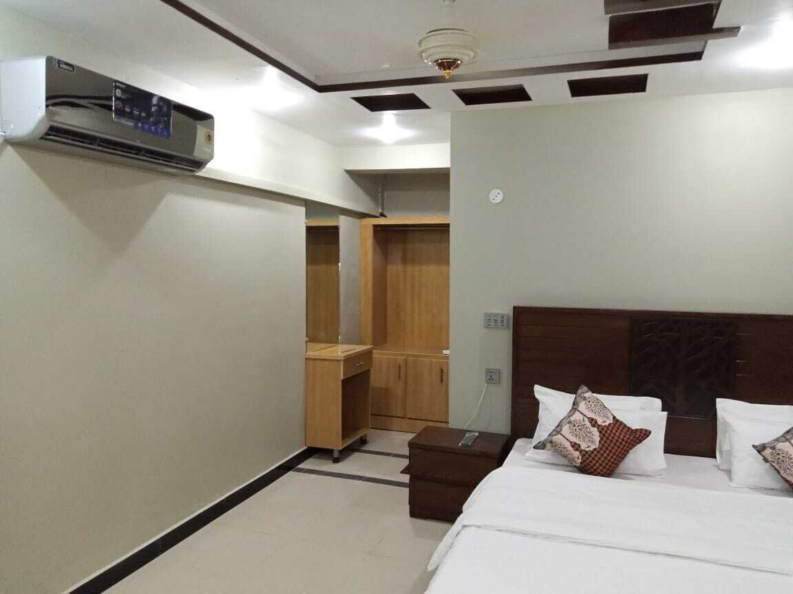 Une chambre d’hôtel équipée d’un lit, d’une table de chevet et d’un appareil de climatisation.