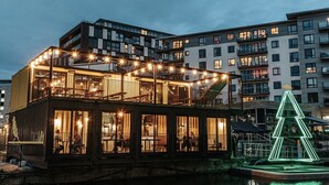 A waterfront building with a balcony and a Christmas tree decoration.