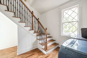 Una escalera con escalones de madera y barandillas negras, que lleva a una plataforma.