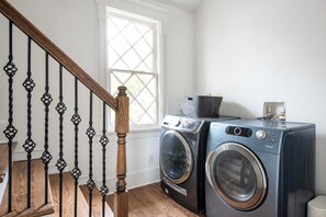 Een wasserette met twee voorladers, een houten trap en een raam.