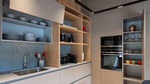 A modern kitchen with built-in appliances, open shelving, and a dining area. - VIP RESIDENCES ANDORRA (El Tarter)