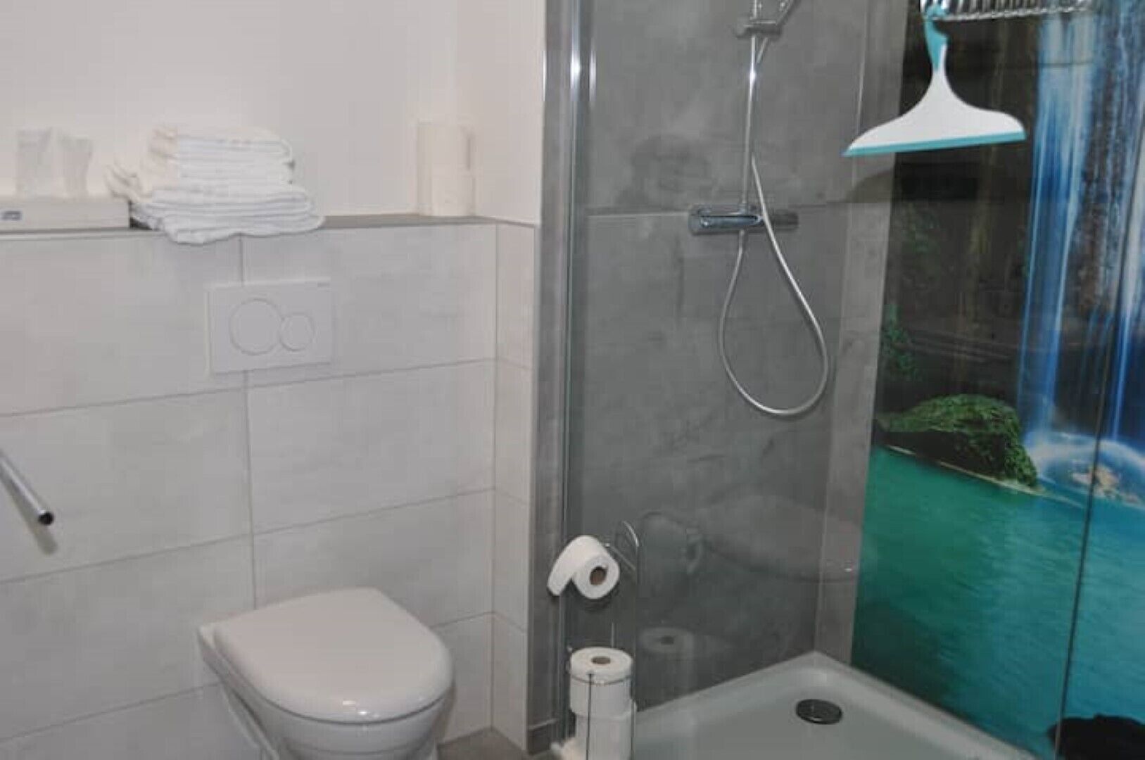 Une salle de bain avec une douche à parois de verre, des toilettes et un lavabo.