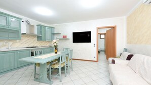 A compact living space with a kitchen, dining area, and a sofa.