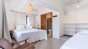 Een slaapkamer met een bed, nachtkastjes, een houten stoel, een hanglamp en een kledingkast.