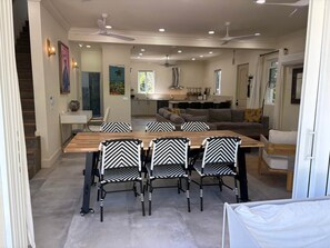 Ein Essbereich mit Holztisch und Stühlen, im Hintergrund eine Küche und eine Treppe.