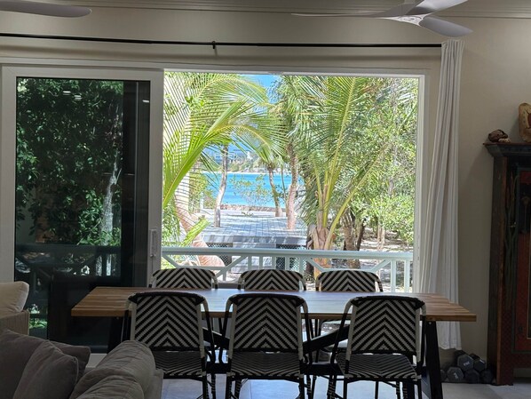 A dining area with a view of palm trees and a pool.