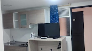 A compact kitchen with a built-in stove, a sink, and a small countertop. - Hotel torre 15  (Bogotá)
