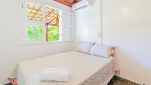 A single bed with a floral bedspread, a white pillow, and a neatly folded white towel. - GB69 Excelente Casa a 400m da Praia (Camaçari)