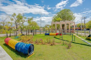 Une aire de jeux avec un toboggan, un tunnel et une structure d’escalade.