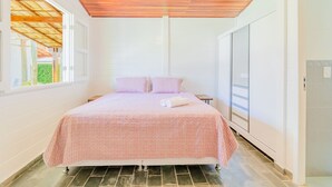 A bedroom with a bed, a ceiling fan, a window, and a door. - GB69 Excelente Casa a 400m da Praia (Camaçari)