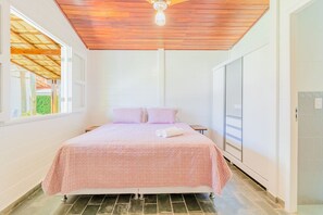 A bedroom with a bed, a ceiling fan, a window, and a door. - GB69 Excelente Casa a 400m da Praia (Camaçari)