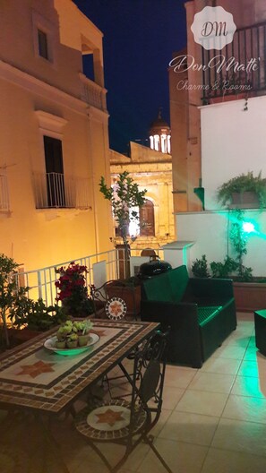 An outdoor patio area with a tiled table, chairs, and potted plants. - DonMattè, Romantic Suite with Terrace in the ancient village. (Conversano)