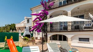A villa with a patio area featuring a slide, lounge chairs, and a barbecue grill. - Vacation home Josipa by Interhome (Kaštela)
