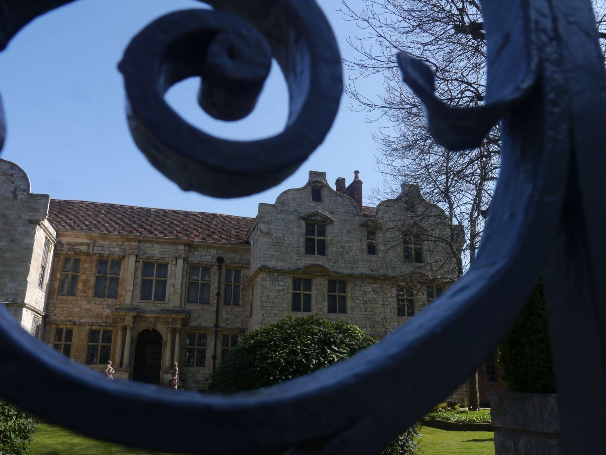 A historic stone building with a symmetrical facade, large windows, and a central entrance.