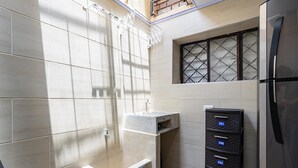 Une salle de bain moderne équipée d’une douche, d’un lavabo et d’un meuble de rangement intégré avec des tiroirs numérotés.