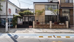 Une rue résidentielle avec une entrée fermée par un portail, un panneau indiquant l’interdiction de se garer et un passage piéton.