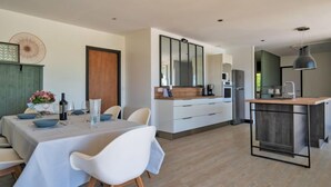 Una cocina moderna con armarios blancos, encimera de madera y horno integrado.