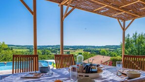Una mesa lista para comer con vistas a una piscina y al campo.