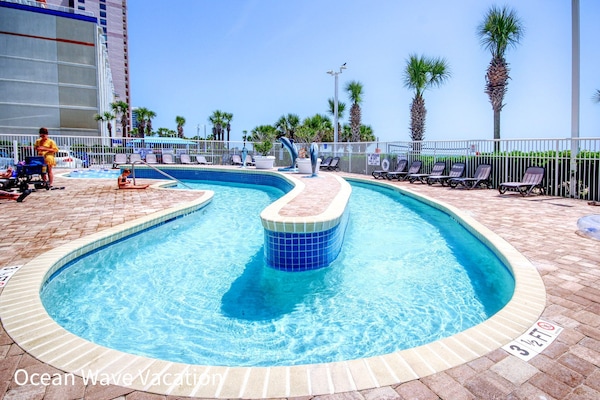 Relaxing lazy river with clear water, loungers, and palm trees all around