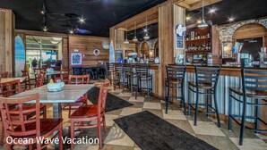 A restaurant with wooden interiors, a bar area, and multiple seating options. - Amazing Beach Condo with Water Park at Dunes Village Resort (Myrtle Beach)