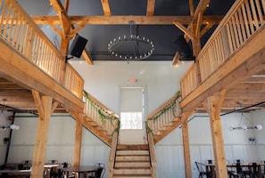 Stairs lead to an upper level, flanked by simple railings and a glass-panelled door.