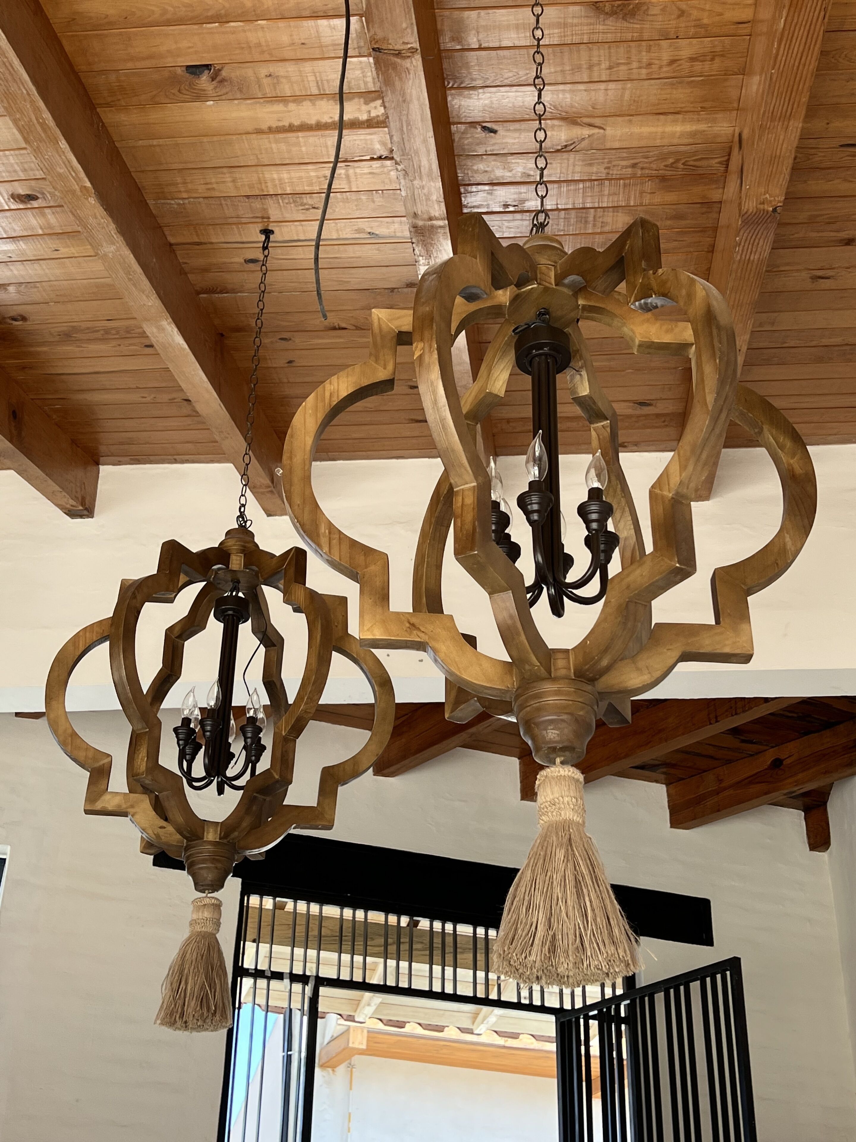 A chandelier with a geometric design and tassels hanging from the ceiling.